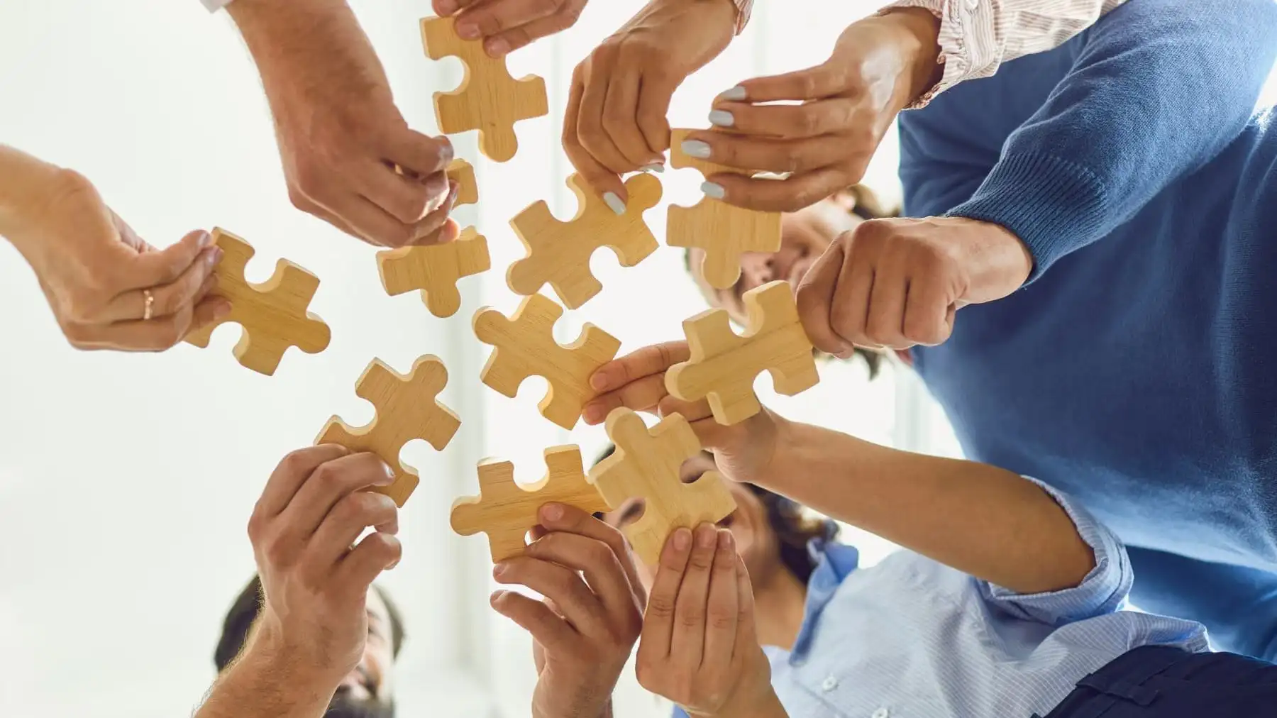 Image of people joining parts of a puzzle.
