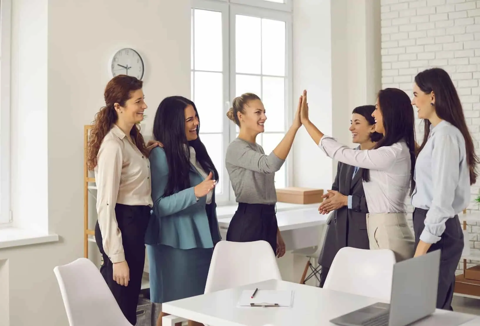 Image of a group of women celebrating the closing of some business or deal.